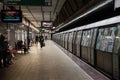 BUCHAREST, ROMANIA - MARCH 13, 2023: Selective blur on people waiting for a metro in Bucharest metro, arriving in the station.