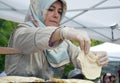 Bucharest, Romania. May 22, 2016. Turkish woman supervizes the baking process of a traditional flat bread on a saj oven, at the Tu