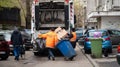 Two workers loading mixed domestic waste in waste collection truck