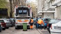 Two workers loading mixed domestic waste in waste collection truck