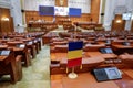 Romanian flag and empty seats in the Romanian Chamber of Deputies inside the Palace of Parliament.