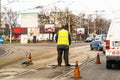 Worker arranging traffic cone on tram railway in Bucharest, Romania