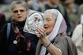 Details with a senior woman holding an Orthodox Church icon during a political rally