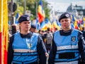 Female police officers and Gendarmerie or military police closely supervising the