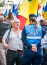 Female police officers and Gendarmerie or military police closely supervising the demonstrators