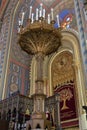 A large ornately decorated lamp stands on the floor in the synagogue Coral in Bucharest city in Romania
