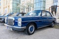 One vivid blue Mercedes 220D (115W) vintage car produced in year 1975 and parked in a street