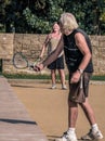 Bucharest/Romania - 09.19.2020: Old couple playing tennis in the park. Selectiv focus on the lady in the background