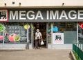 Bucharest/Romania - 06.22.2020: Old man wearing a face mask exiting the store . Mega image supermarket is a part of Delhaize group Royalty Free Stock Photo