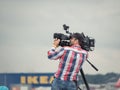 Camera operator filming an event in Bucharest, Romania, using a modern videocamera