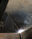 Shallow depth of field selective focus details with a professional welder welding an industrial metallic pipeline Royalty Free Stock Photo