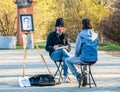 Street artist cartoonist or painter making portraits to people in Herestrau park Kink MIhai I,