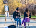 Street artist cartoonist or painter making portraits to people in Herestrau park Kink MIhai I,