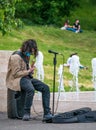 Bucharest/Romania - 05.23.2020 Young man with long hair playing guitar. Street artist performing Royalty Free Stock Photo