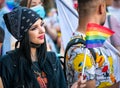 Young woman holding the rainbow flag, symbol of LGBT and queer pride at LGBTQ Pride parade in