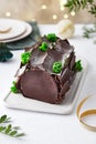 Buche de Noel. Traditional Christmas dessert, Christmas yule log cake with chocolate cream. Christmas tree branches. Royalty Free Stock Photo