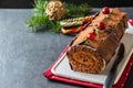 Buche de Noel. Traditional Christmas dessert, Christmas yule log cake with chocolate cream, cranberry. On stone gray Royalty Free Stock Photo