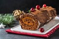 Buche de Noel. Traditional Christmas dessert, Christmas yule log cake with chocolate cream, cranberry. On stone gray Royalty Free Stock Photo