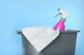 Bucket with bottle of cleaning product and microfiber cloth on light blue background, closeup Royalty Free Stock Photo