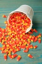 Bucket of candy corns spilled out on wooden floor
