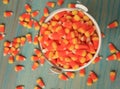 Bucket of candy corns spilled out on wooden floor