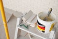 Bucket with cement, tile spacers and many white decorative bricks in room Royalty Free Stock Photo