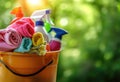 A bucket of cleaning products on a blurred green background: cleaning wipes, rags and bottles. The concept of cleanliness and