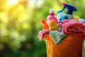 A bucket of cleaning products on a blurred green background: cleaning wipes, rags and bottles. The concept of cleanliness and