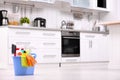 Bucket with cleaning supplies on floor in kitchen