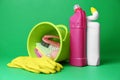 Bucket, cleaning supplies and tools on green background Royalty Free Stock Photo