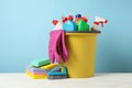 Bucket with detergent and cleaning supplies on blue background Royalty Free Stock Photo