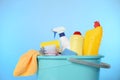 Bucket with different cleaning products and supplies on light blue background, closeup Royalty Free Stock Photo