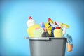 Bucket with different cleaning products and supplies on light blue background, closeup Royalty Free Stock Photo