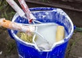 A bucket with dirty brushes and rollers for whitewashing Royalty Free Stock Photo