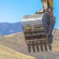 Bucket of an excavator against mountain and sky Royalty Free Stock Photo