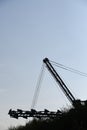 Bucket excavator standing as dark silhouette at blue sky