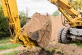 A bucket of excavator with a pile of sand and a ground background. Industrial work on the construction site Royalty Free Stock Photo
