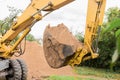 A bucket of excavator with a pile of sand and a ground background. Industrial work on the construction site Royalty Free Stock Photo