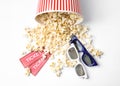 Bucket of fresh popcorn, tickets and 3D glasses on background, top view. Cinema snack