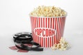 Bucket of fresh popcorn, tickets and movie reel on background. Cinema snack Royalty Free Stock Photo