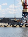 The bucket of a harbor crane in a large pile of black coal Royalty Free Stock Photo