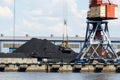 The bucket of a harbor crane in a large pile of black coal Royalty Free Stock Photo