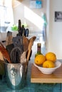 Bucket with many kitchen utensils and a bowl with lemons