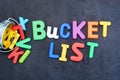 Bucket list concept, things to do in life with iron bucket and magnetic letters on chalkboard