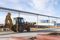 A bucket loader carries out loading of coal in an open port warehouse on a background of black mountains of coal Royalty Free Stock Photo