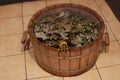 Bucket made of wood filled with water with hand-made broom soaking in bright sauna room. Having healthy rest time in Royalty Free Stock Photo