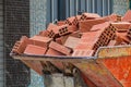 The bucket of a mini loader, which carries a fully loaded red brick down the street. An example of solving problems with low costs Royalty Free Stock Photo