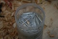 A bucket of nails on the woodworking bench.