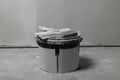 Bucket with plaster and putty knife near wall indoors Royalty Free Stock Photo