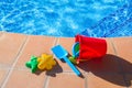 Bucket with plastic beach toys near pool Royalty Free Stock Photo